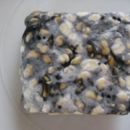 Sporulating tempeh, visible by patches of black.